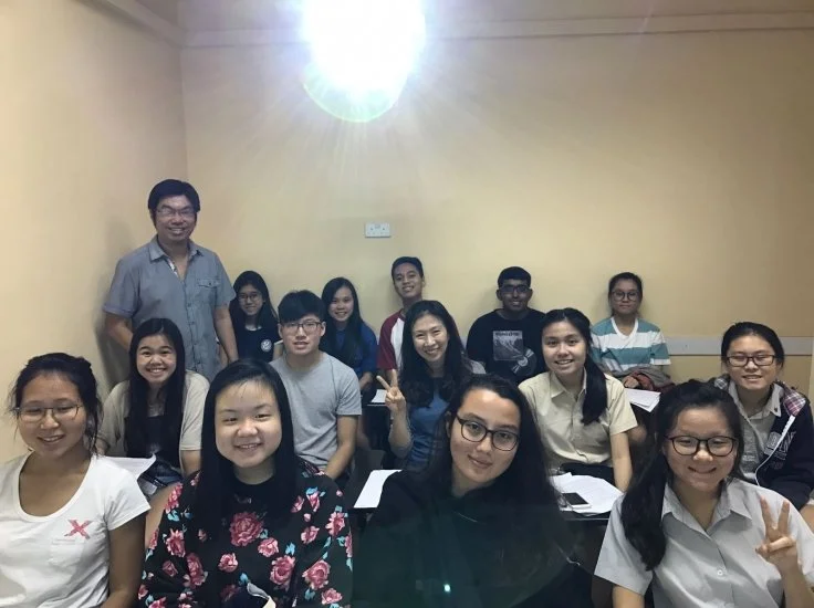 Students attending a math tuition class at Andrew Yap Education Centre in Singapore, guided by their teacher in a supportive classroom setting.
