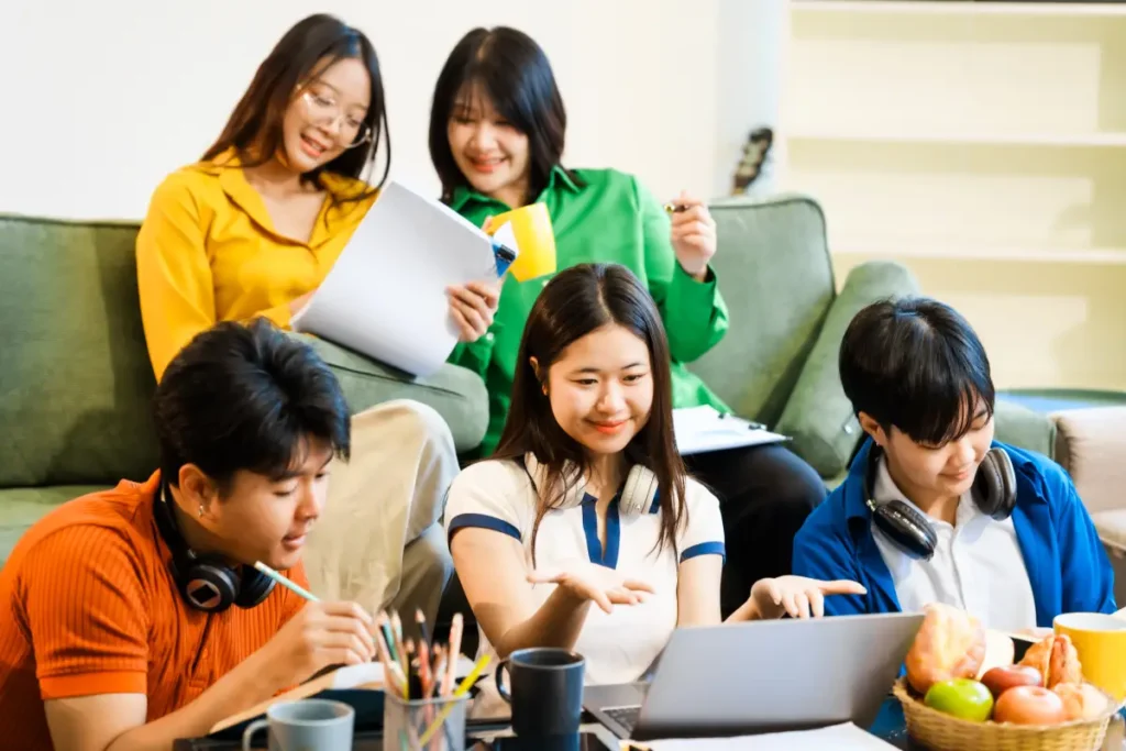 Group of Asian teens studying in a living room