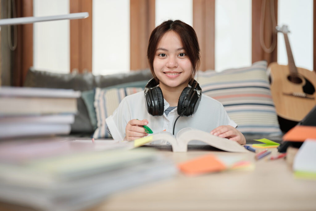 Young teenager smiling while studying at home