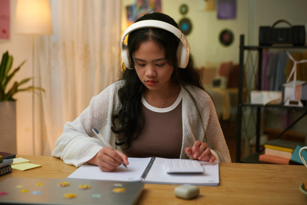 JC1 student using a calculator while completing Math practice as part of her revision for upcoming promotional examinations.