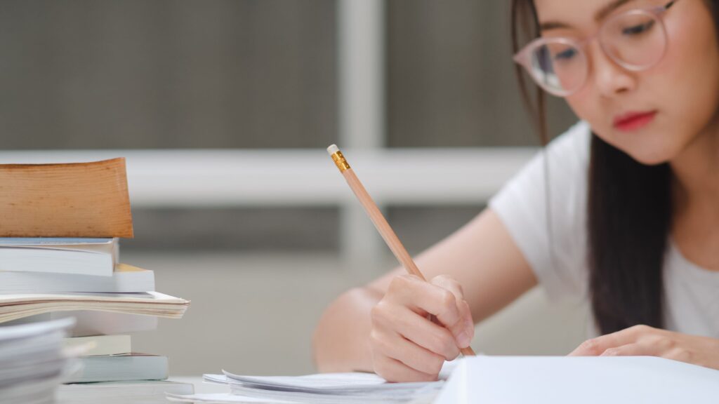 Secondary school student completing A-Math practice questions while reviewing her working to identify and correct recurring mistakes.
